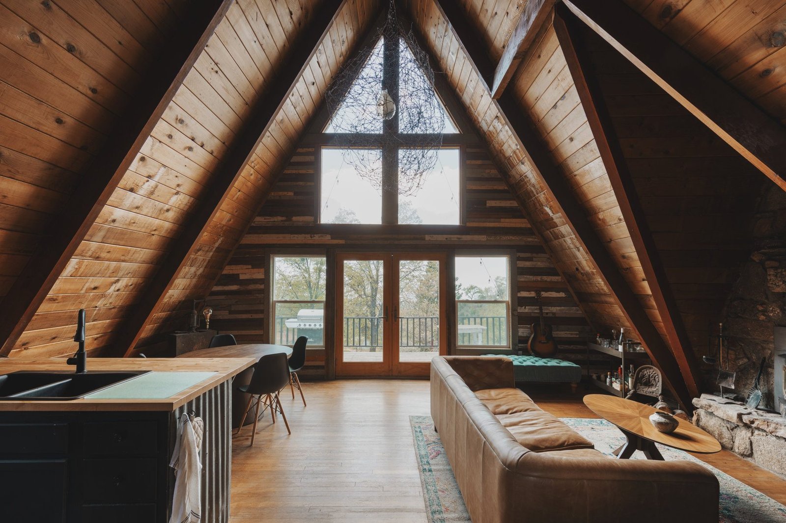 Inside the A-frame, with timber beams and tall windows